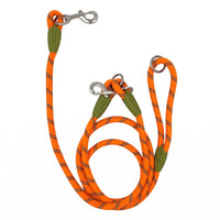 Laisse mains libres pour chien orange avec anneaux et mousquetons sur fond blanc